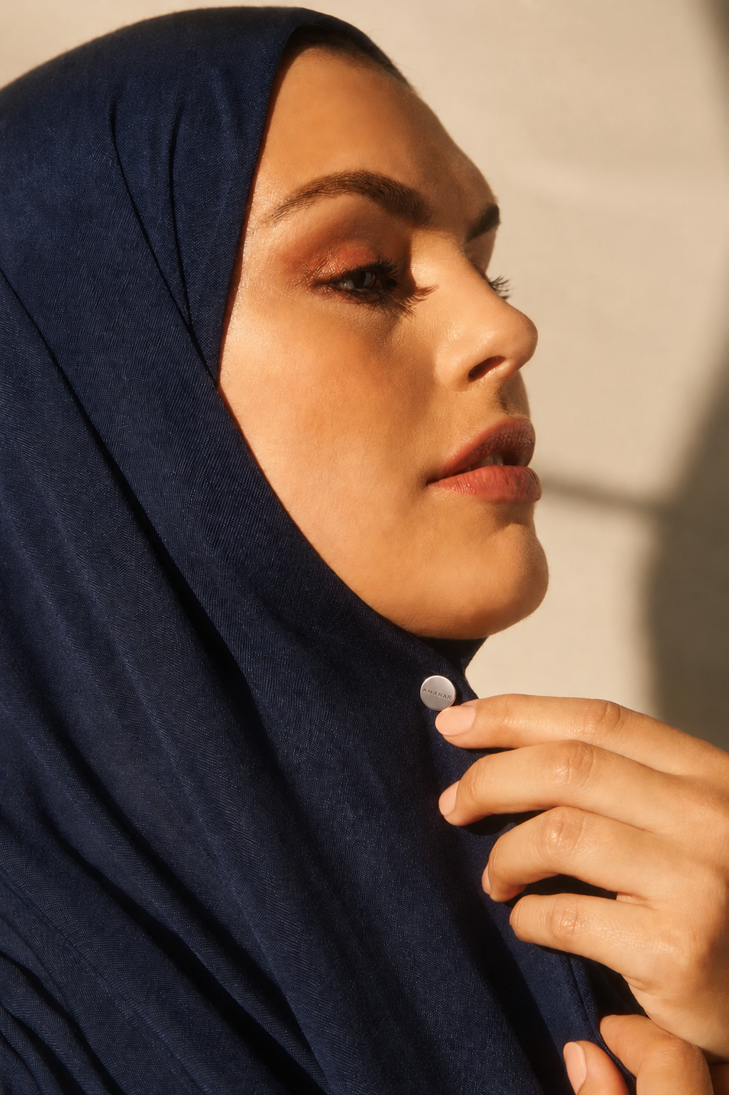 Close-up of a woman wearing with a small silver AMANAH hijab magnet.