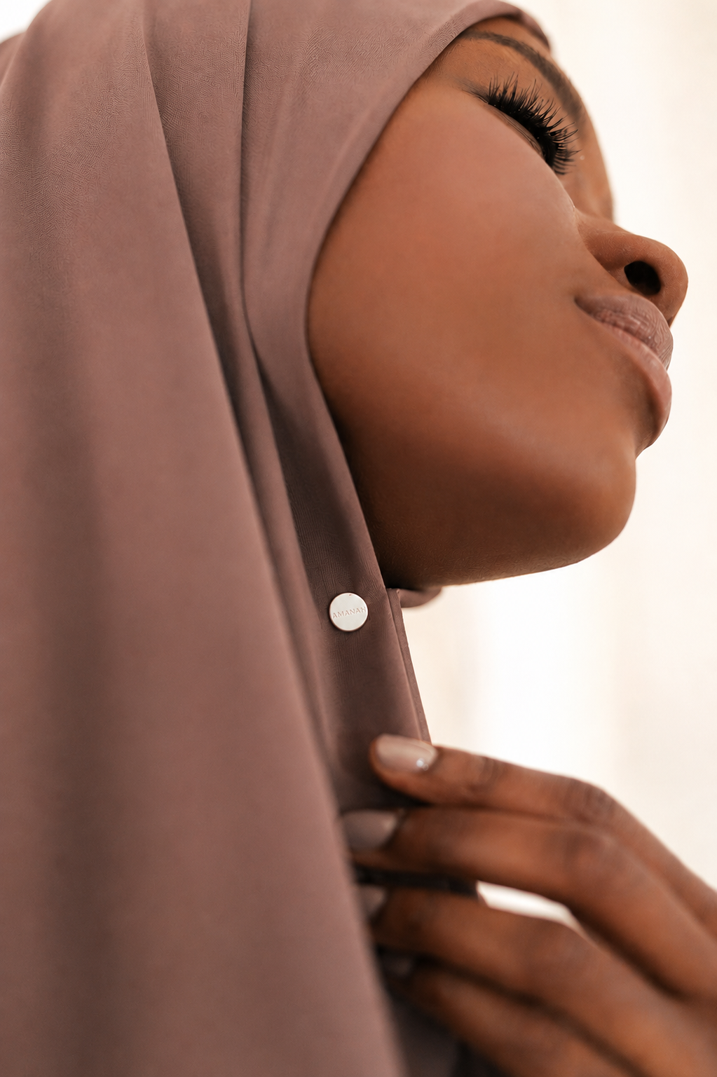 Close-up of a woman wearing with a small white AMANAH hijab magnet.