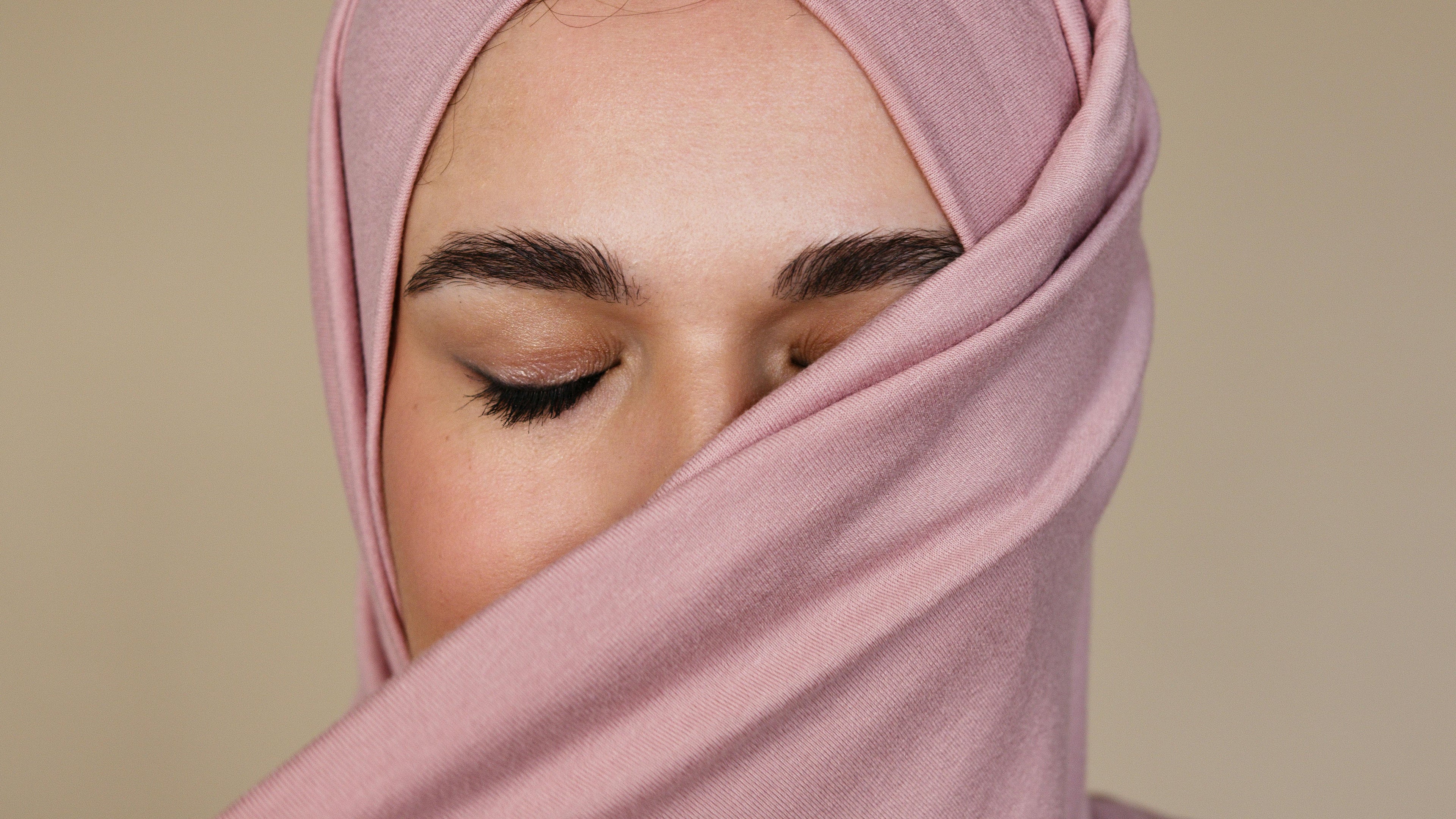 Close-up of soft pink jersey hijab fabric gently wrapped, highlighting smooth texture and breathable material for everyday comfort