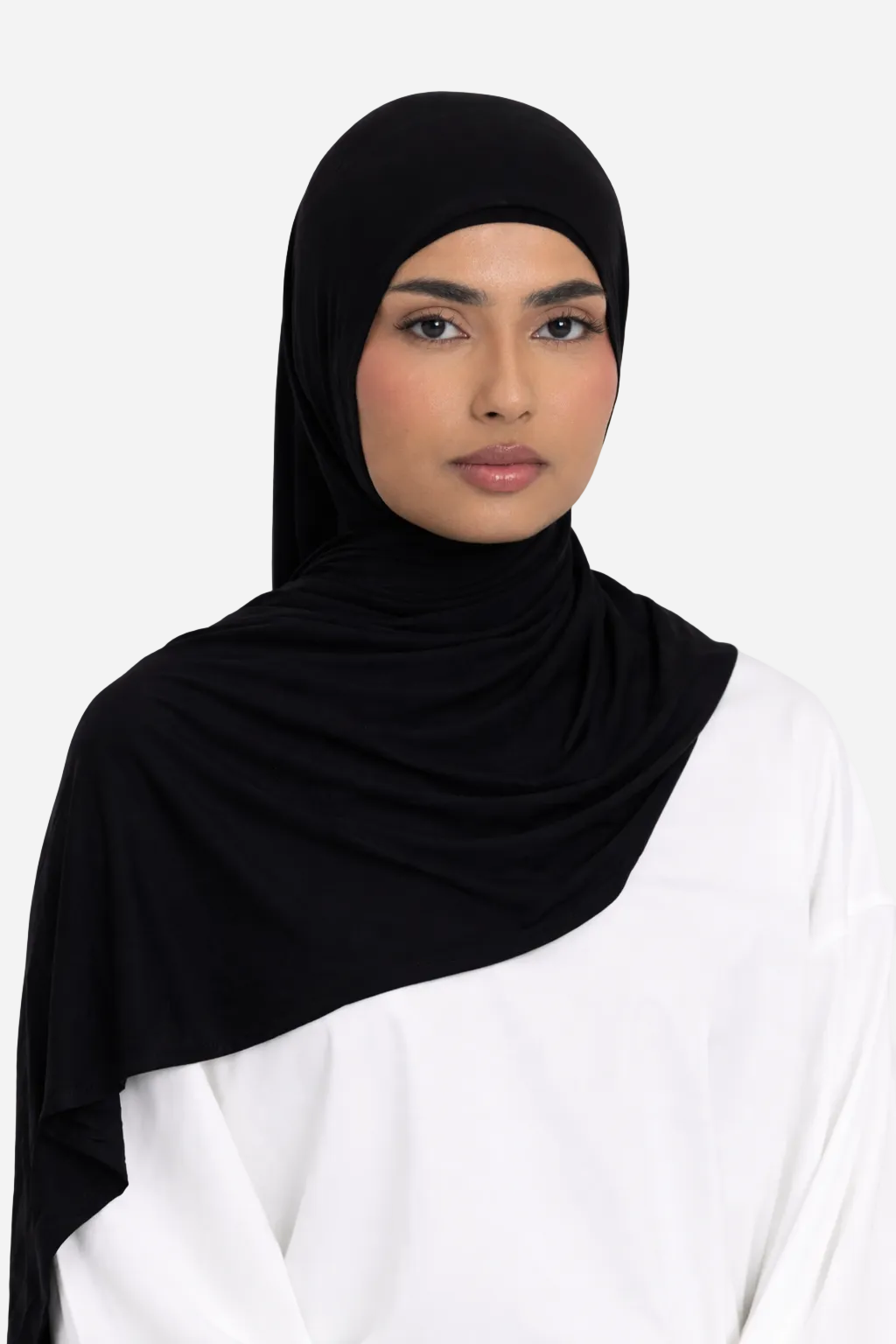 Woman wearing a black premium bamboo jersey hijab by Amanah styled smoothly over a white outfit