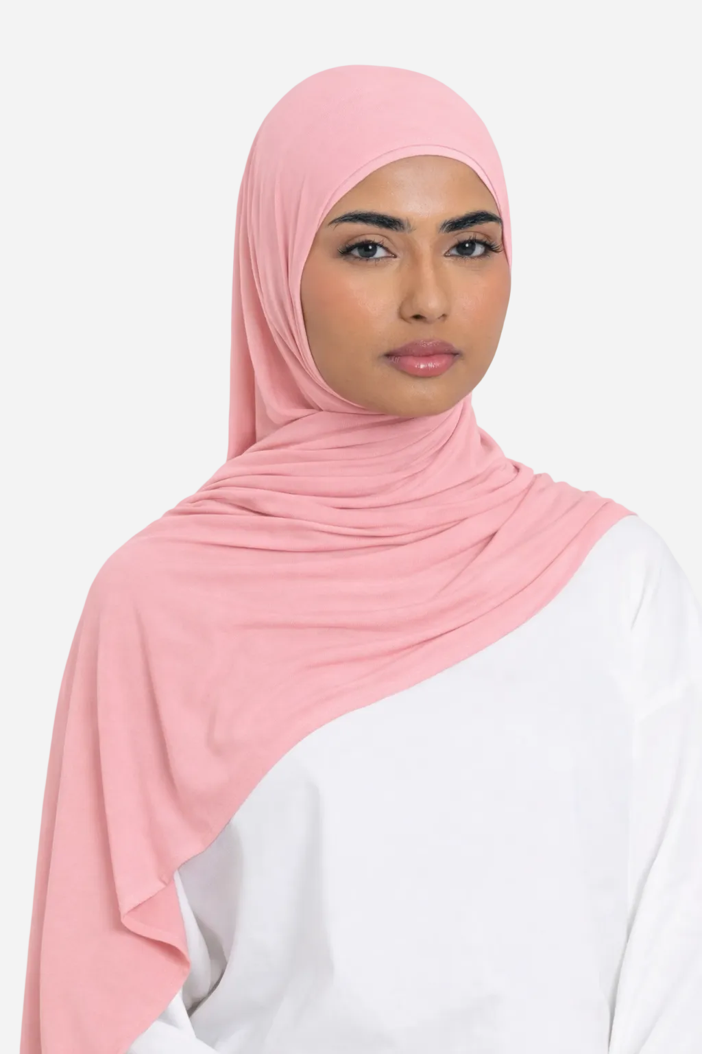 Woman wearing a rose premium bamboo jersey hijab by Amanah styled smoothly over a white outfit
