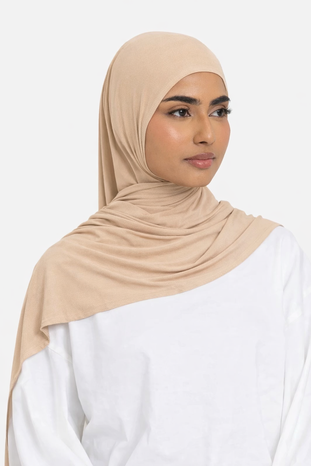 Model wearing a sand premium bamboo jersey hijab by Amanah, showing a smooth, secure, and elegant drape