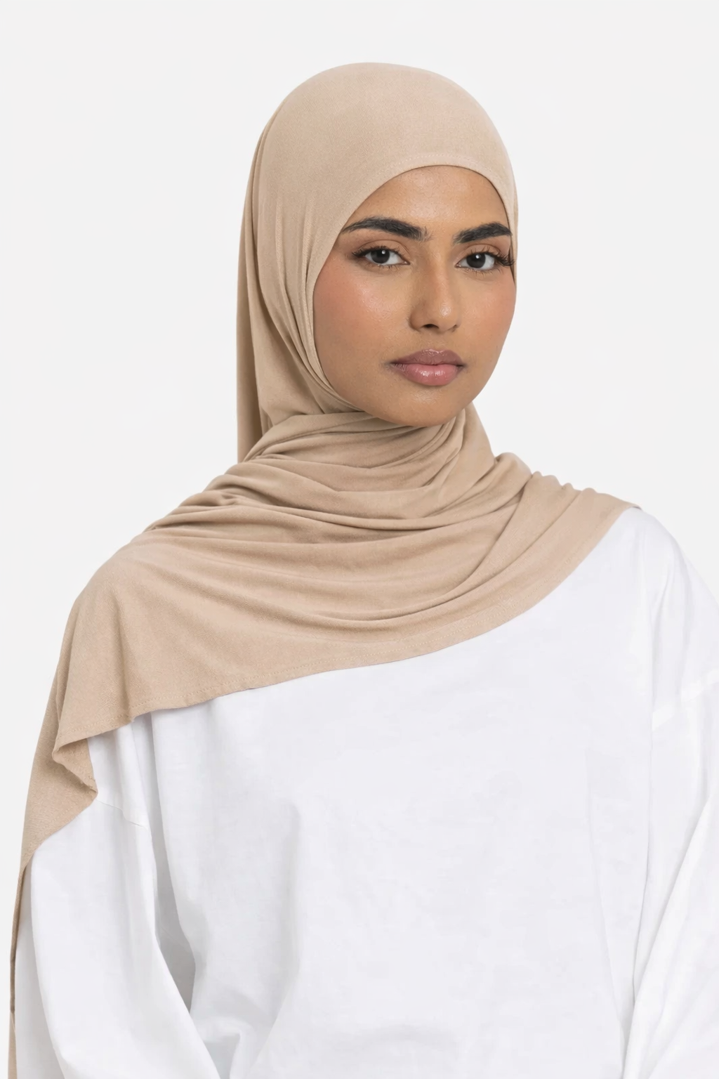 Woman wearing a sand premium bamboo jersey hijab by Amanah styled smoothly over a white outfit